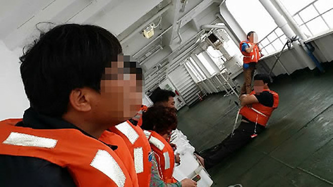 Bức ảnh do một người sống sót chụp cho thấy hành khách cố gắng tìm cách giữ thăng bằng khi phà bị nghiêng và đang chìm dần.