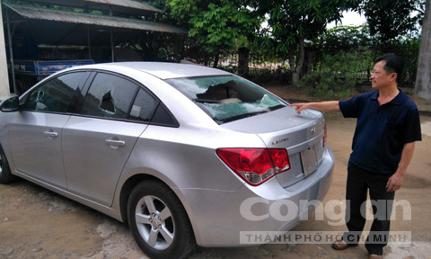 Ông Thuận bên chiếc xe ôtô bị đập vỡ 3 cửa kính.