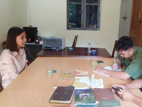 Đối tượng Nguyễn Thị Ánh Nguyệt cùng các tài liệu, vật dụng liên quan đến sinh hoạt, truyền đạo trái phép tại cơ quan chức năng. Ảnh: Xuân Tiến/TTXVN.