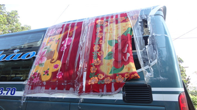 Nhà xe Mai Thảo bị ném vỡ kính, phải dùng chăn che tạm để tiếp tục hành trình trong đêm tối.