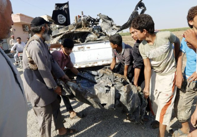 Các tay súng IS thu lượm mảnh xác máy bay quân đội Syria