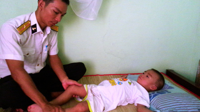 Thiếu úy Đinh Văn Đồng và cháu Quân. ảnh: TC