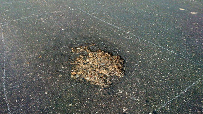 Hiện trường mặt đường bê tông nhựa bị rải hóa chất phá hoại. Ảnh: Đặng Tài.