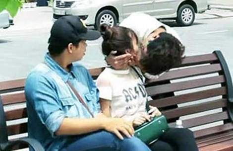 Một cặp đôi đang ngồi tâm sự trên ghế nơi công viên bị người lạ bất ngờ “bẻ cổ” hôn môi cô gái. Ảnh cắt từ clip.