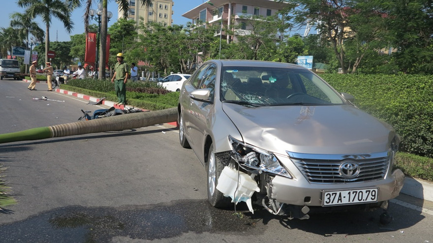 Camry kéo lê xe máy trên phố, đâm gãy cây dừa lớn