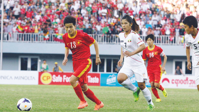 Các cô gái Việt Nam (đỏ) sẽ chịu sự cạnh tranh quyết liệt từ những đối thủ trong khu vực là Myanmar (trắng) và Thái Lan để giành vé thứ 5 dự World Cup 2015. ảnh: T.Vũ 