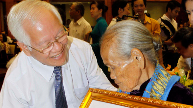 Chủ tịch UBND TPHCM trao tặng danh hiệu Mẹ VNAH cho mẹ Đặng Thị Thu. Ảnh: TTXVN