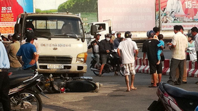 Xe ô tô tải cuốn xe gắn máy dưới gầm.