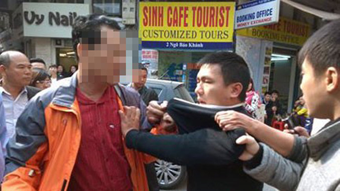 Anh Tuấn (áo khoác cam) dũng cảm khống chế tên cướp áo đen. Ảnh: Facebook Vu Tuan Anh.