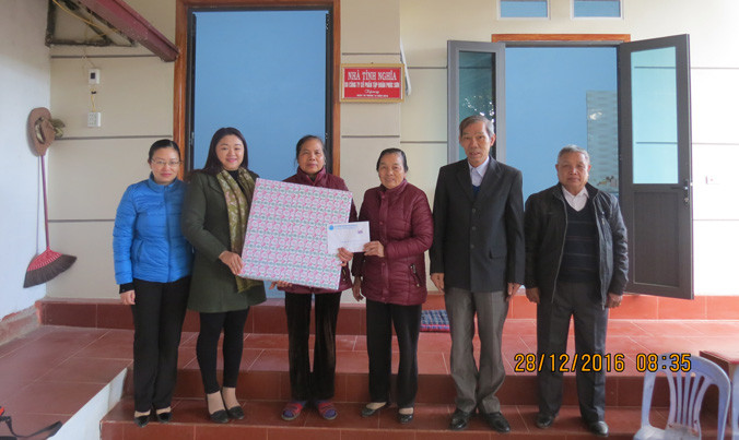 Các đại biểu trao quà cho hộ gia đình cựu Thanh niên xung phong.