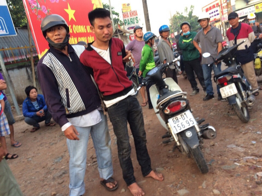 Đối tượng trộm xe (áo đỏ) bị bắt giữ cùng với tang vật.