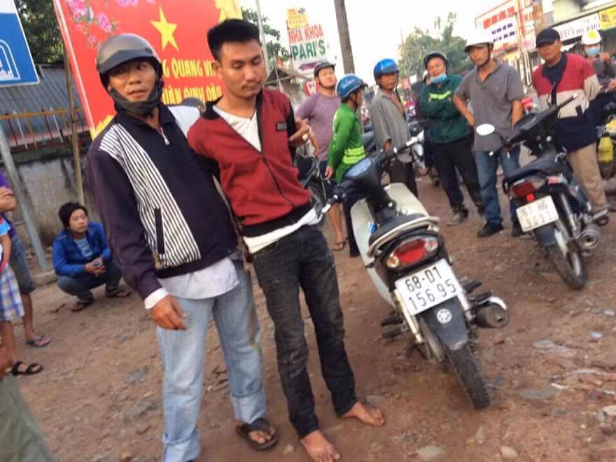 Đối tượng trộm xe (áo đỏ) bị bắt giữ cùng với tang vật.