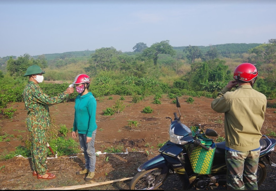 Cán bộ biên phòng đo thân nhiệt cho người dân