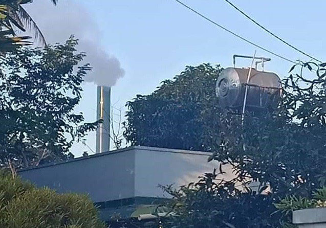 Ống khói đen khịt của cơ sở chế biến cà phê đặt trong khu dân cư