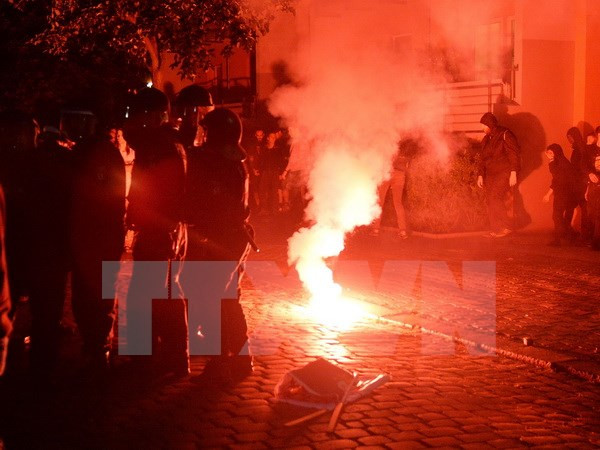 Cảnh sát phun hơi cay giải tán đám đông biểu tình quá khích tại Berlin. (Nguồn: EPA/TTXVN)