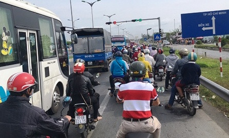 Theo ghi nhận, trưa mùng 4 Tết, trên Quốc lộ 1A, rất nhiều phương tiện xe gắn máy từ các tỉnh miền Tây nối đuôi nhau về TP Hồ Chí Minh. 