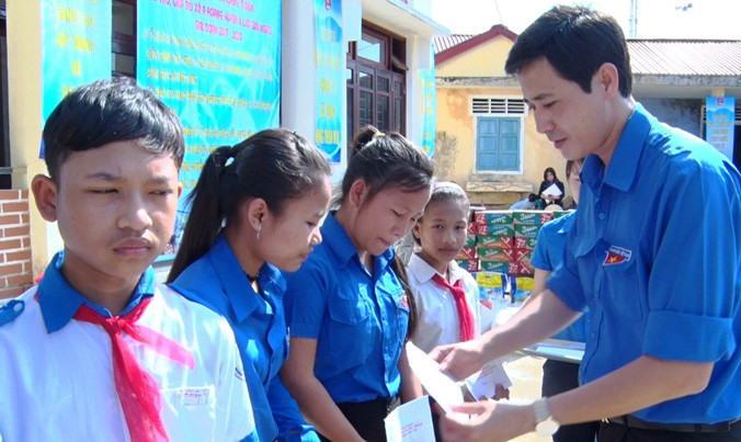 Trao học bổng cho học sinh nghèo vượt khó tại lễ phát động giúp đỡ xã nghèo vùng núi A Lưới. 