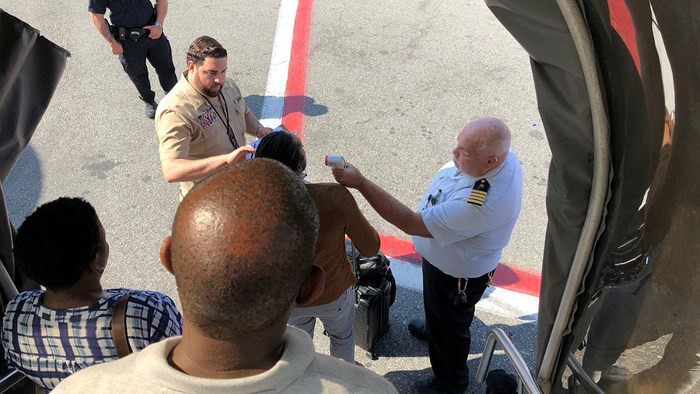 Nhân viên cứu hộ kiểm tra thân nhiệt của những hành khách trên máy bay.