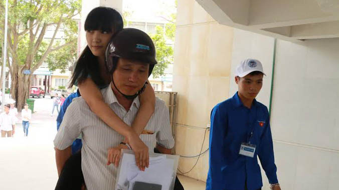 Ông Lê Văn cõng con gái tới điểm thi.