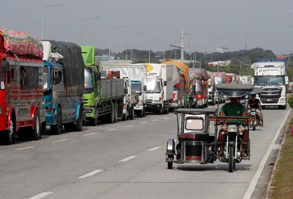 Xe tải mắc kẹt trên lề đường do các chuyến phà bị đình chỉ trước khi bão Yutu đổ bộ đất liền tại cảng Batangas, Philippines vào ngày 29/10/2018. Ảnh: Reuters / Erik De Castro