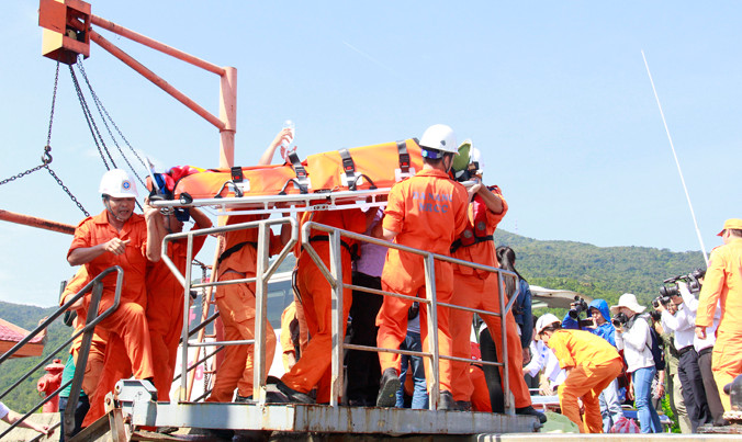 Lực lượng tìm kiếm cứu nạn đưa ngư dân bị nạn lên bờ. Ảnh: Thanh Trần.