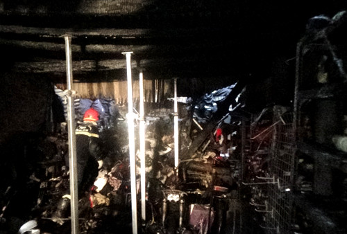 Để vào tìm nạn nhân, cảnh sát cứu hộ phải chống đỡ căn gác sắp sập đổ. Ảnh: C.H