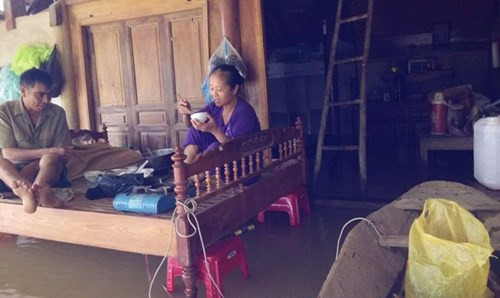 Bữa ăn đầu tiên trong 3 ngày lũ với nồi cơm sống một nửa của ông bà Thân, xóm 1 Phương Điền. Ảnh: VH.