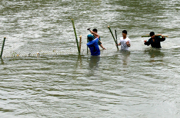 Các lực lượng chức năng dùng lưới chắn phía hạ nguồn để tìm kiếm tung tích nạn nhân.