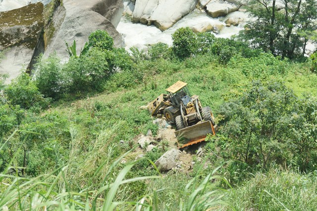 Chiếc máy xúc bánh hơi tiền tỷ do một công nhân Trung Quốc điều khiển lao xuống vực sâu cạnh quốc lộ 4D từ hồi đầu tháng 7 và vẫn nằm ở đó cho tới nay. Ảnh chụp ngày 22/8.
