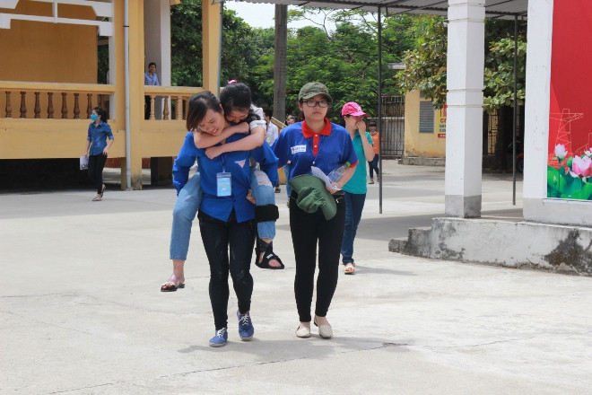 Thí sinh Ngô Thị Quỳnh Huyền được sinh viên tình nguyện cõng ra khỏi phòng thi