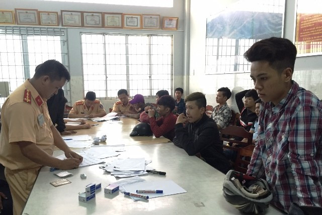 Các thanh niên tụ tập cổ vũ, tham gia đua xe trái phép được đưa về trụ sở Công an xử lý. Ảnh Minh Anh