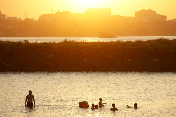 Dưới chân cầu Vĩnh Tuy phía tả ngạn sông Hồng, nhiều bãi bồi tự nhiên thoai thoải phủ cỏ xanh mướt đang trở thành những bãi tắm hấp dẫn người dân đổ về trong những ngày hè nóng nực. 