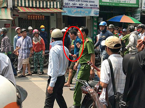 Thành (áo xanh đậm) bị đưa về trụ sở