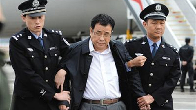 Quan tham Lí Hoa Ba bị bắt đưa về Trung Quốc. Ảnh Tân Hoa Xã.