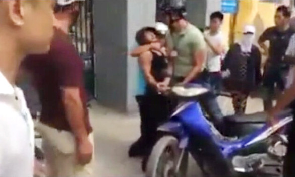 Thanh niên mậc áo màu xanh ghì cổ người vi phạm, xưng hô mày tao với dân. Ảnh cắt từ clip