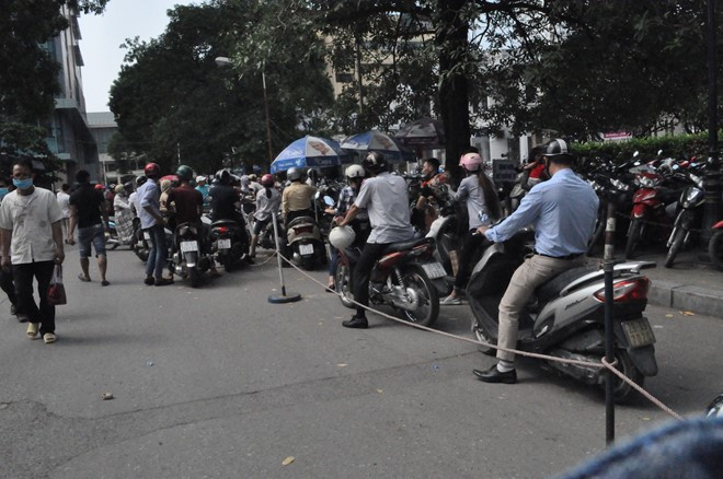 Người dân khốn khổ khi BV Bạch Mai đóng cửa bãi trông giữ xe. Ảnh: Anh Văn