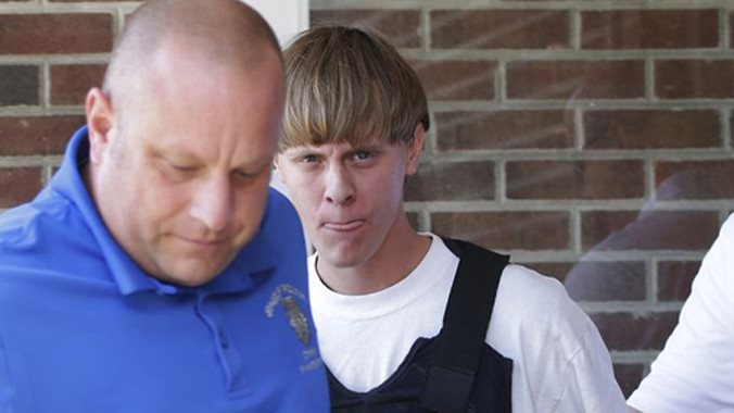 Nghi phạm Dylann Roff (áo đen) bị cảnh sát áp giải. Ảnh: AP.