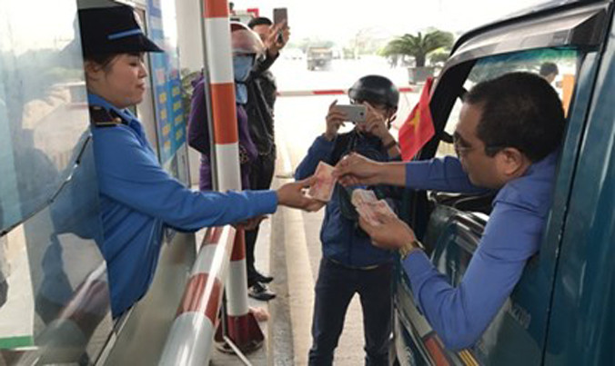 Người dân trả tiền lẻ khi qua trạm thu phí Cầu Bến Thuỷ.