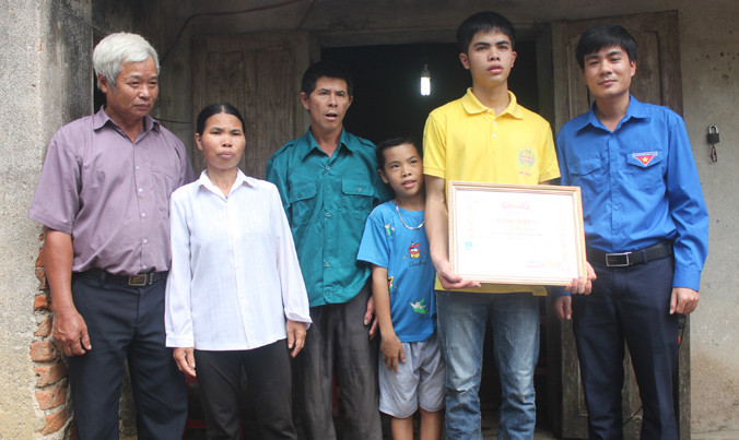Anh Lê Văn Châu - phó bí thư Tỉnh đoàn Thanh Hóa (bìa phải) tặng bằng khen cho em Lê Hữu Hiếu sáng 9/7. Ảnh: Hoàng Lam.