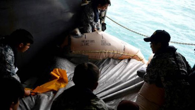 Chiếc bè cứu sinh được vớt lên... Ảnh: The New Paper.