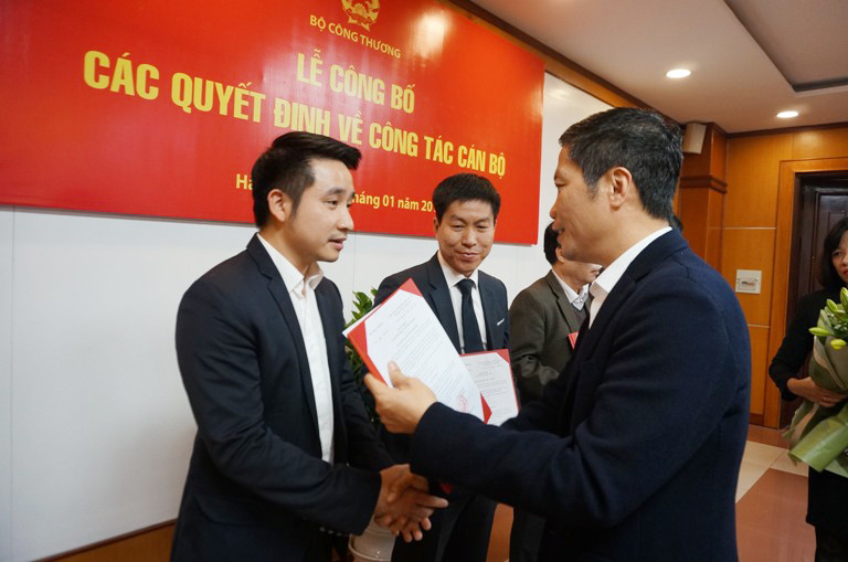 Ông Vũ Hùng Sơn (bìa trái) nhận quyết định của Bộ trưởng Công Thương bổ nhiệm làm Phó cục trưởng cục quản lý thị trường và quyết định biệt phái sang ban 389. 
