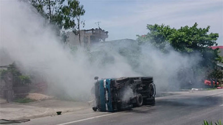 Chiếc xe lật nghiêng và bốc khói nghi ngút (Ảnh: Dân trí)