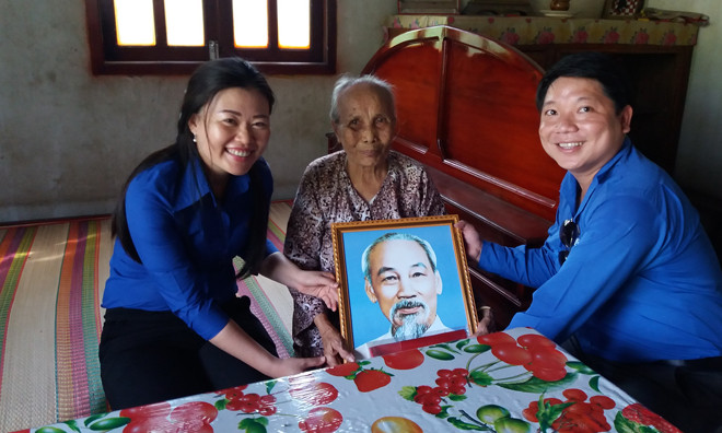 Chị Phạm Thị Thùy Dung Bí thư Tỉnh Đoàn Hậu Giang (bìa trái) tặng ảnh bác cho Mẹ Việt Nam anh hùng.