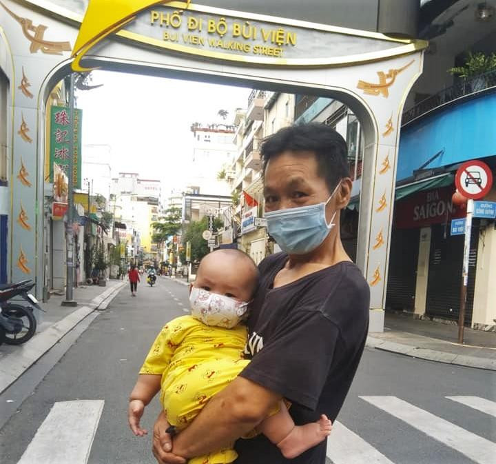 Bác Huy, người dân phố Tây đưa cháu 6 tháng tuổi đi sưởi nắng trên phố Bùi Viện chiều 30/9/2021. Bác nói: "Không có gì vui hơn khi hai ông cháu lần đầu được dạo phố thể dục sau nhiều tháng giãn cách nghiêm ngặt". 
