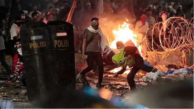 Người biểu tình ném đá vào cảnh sát. (Ảnh: Reuters)