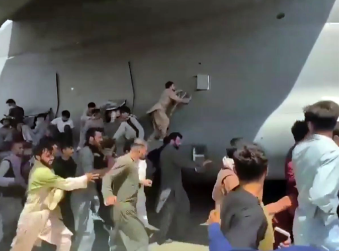 Người dân Afghanistan đu bám chiếc máy bay để mong thoát khỏi đất nước. (Ảnh: AP)