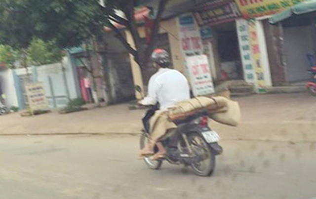 Hình ảnh anh Lò Văn Muôn chở thi thể người em gái của mình là chị P. về nhà bằng xe máy, được một người đi đường chụp lại, đã gây xôn xao dư luận mấy ngày qua (Ảnh: Facebook Tùng Hải).