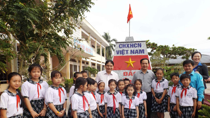 Anh Vinh chụp ảnh cùng học sinh trường tiểu học Thị trấn Kinh Cùng. A