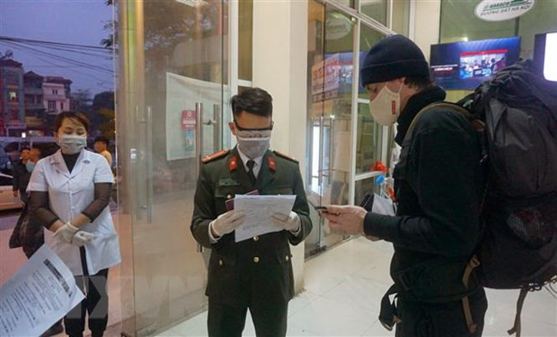 Du khách người nước ngoài phải đối chiếu tờ khai y tế với hộ chiếu khi xuống tàu ở Ga Lào Cai. (Ảnh: Quốc Khánh/TTXVN)