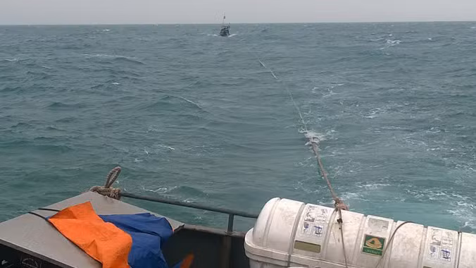 Tàu cá QNa 01059 trên đường được tàu BP 43-1302 lai dắt vào bờ. Ảnh: Hải đội 2 cung cấp.